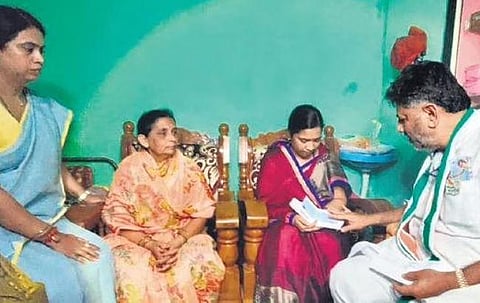 KPCC president DK Shivakumar gives a cheque of Rs 11 Lakh to the family of  civil contractor Santosh Patil at Badas village near Belagavi on Tuesday 