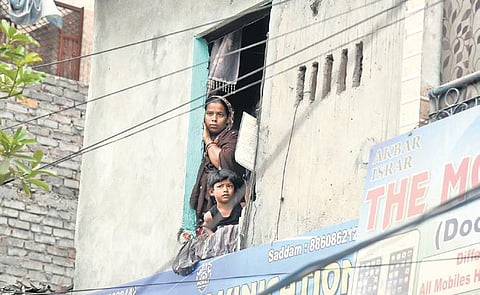 Residents look out from their houses a day after demolition | Parveen Negi