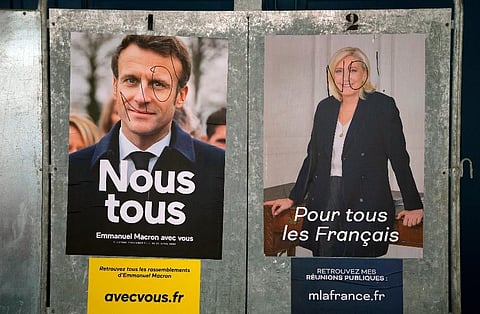 Presidential campaign posters of French President and centrist candidate for reelection Emmanuel Macron, and candidate Marine Le Pen. (Photo | AP)