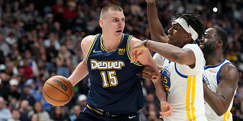 Denver Nuggets' Nikola Jokic (L) looks to pass the ball as Golden State Warriors' Kevon Looney and Draymond Green defend in the second half of an NBA match in Denver. (Photo| AP)