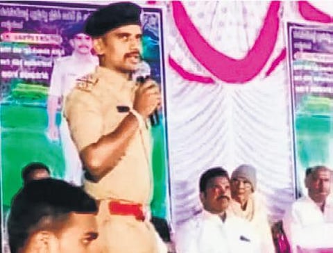 Police constable Basangouda Karegoudra wearing a PSI uniform addresses the crowd at Gudisalakopa
