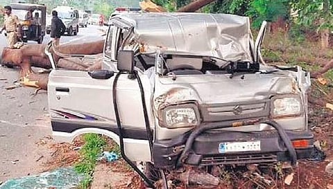 The mangled remains of a Maruti Omni, on which a tree branch fell on Monday morning, killing the driver and his toddler son, on the Bengaluru-Mysuru highway.