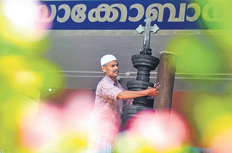 Nazar Hameed engaged in cleaning the stone lamp installed in front of St Mary’s Jacobite Syrian Church in Thodupuzha |Shiyami