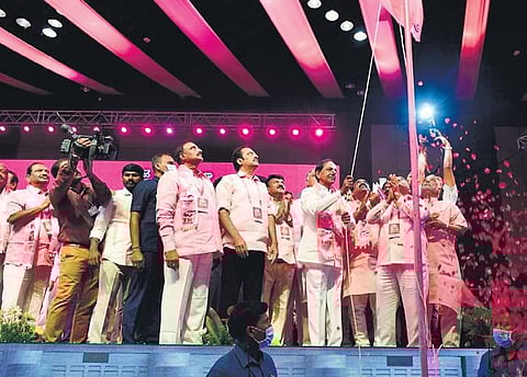 Chief Minister K Chandrasekhar Rao hoists the party flag at the 21st plenary of the TRS at the HICC, while women leaders, right, give a thumbs up  on Wednesday