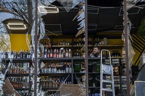 A liquor store owner looks at the damage to his shop caused by an explosion in Kyiv, Ukraine. (Photo | AP)