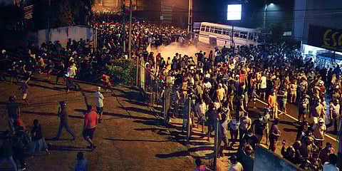 Protesters run to take cover as police uses tear gas shells to disperse them during a protest outside Sri Lanka President Gotabaya Rajapaksa's private residence. (Photo | AP)