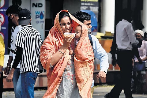 A mother protects her child from the scorching heat at Connaught Place. (File Photo| PARVEEN NEGI)