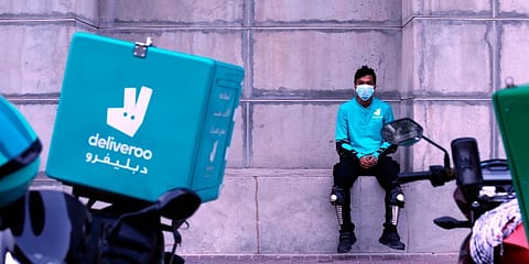 A food-delivery worker for Deliveroo takes a moment as he returns to work in Dubai, United Arab Emirates, May 2, 2022. (Photo | AP)