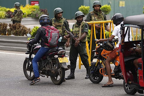 Sri Lankan army soldiers stand guard as motorists cross a checkpoint outside prime minister's residence. (Photo | AP)