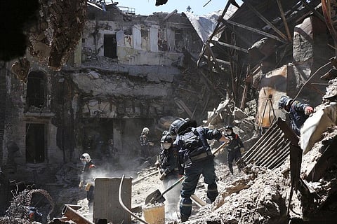 Ministry employees clear rubble at the side of the damaged Mariupol theater building during heavy fighting in Mariupol, in territory under the government of the Donetsk People's Republic, Ukraine| AP