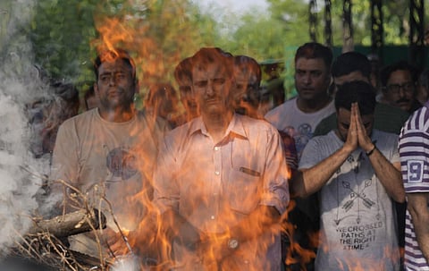 Relatives and friends attend the cremation of Kashmiri Pandit Rahul Bhat, in Srinagar. (Photo | AP)