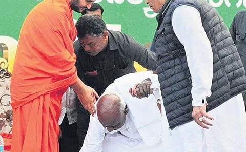 Former PM H D Deve Gowda seeks blessings from Kunchatiga Vokkaliga religious head Sri Nanjavadhuta at the valedictory event of Janata Jaladhare on Friday
