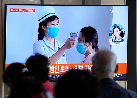 People watch a TV screen showing a news report about the COVID-19 outbreak in North Korea, at a train station in Seoul. ( Photo| AP)