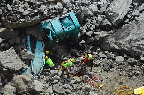 Police said that a giant boulder rolled over crushing three lorries and three cranes and six people were stuck under the rocks. (Photo | V Karthikalagu, EPS)