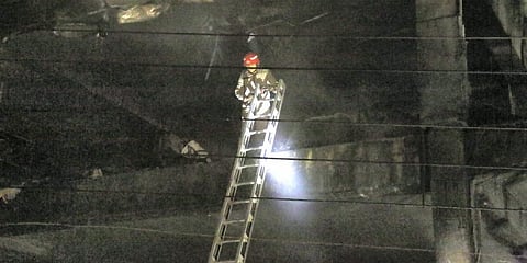 A Fire Brigade personnel at rescue work after a massive fire which broke out at an office building near the Mundka Metro Station, in New Delhi. (Photo | PTI)