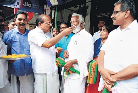 Thrikkakara BJP candidate A N Radhakrishanan giving sweets to former Mizoram governor Kummanam Rajasekharan to celebrate the victory of BJP candidates in the local body elections. (Photo | express)