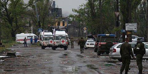 Red Cross staff drive by in their vehicles to the besieged Mariupol's Azovstal steel plant to observe the evacuation of Ukrainian servicemen from Azovstal steel plant, in Mariupol. (Photo| AP)