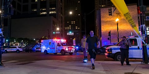 A Chicago Fire Department ambulance travels to a local hospital as Chicago police work at the scene of a shooting near East Chicago Avenue and North State Street. (Photo | AP)