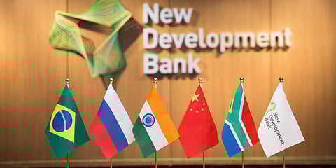 The logo of New Development Bank is seen in the background with flags of its member nations. (Photo| Special Arrangement)