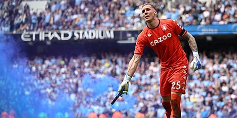 Aston Villa goalkeeper Robin Olsen removes a smoke bomb during the EPL football match against Manchester City at the Etihad Stadium in Manchester, north-west England. (Photo | AFP)