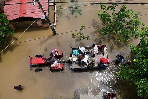 BBMP workers carrying food packets to distribute to residents of Vaddarapalya near Horamavu who  were severely affected due to heavy rainfall. (Photo | Shriram BN, EPS)