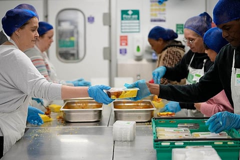 Volunteers from the charity 'The Felix Project' prepare meals in the kitchen of their hub in London. (Photo | AP)