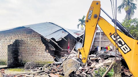 An earthmover during an eviction drive carried out by district administration in Nagaon district, Assam.