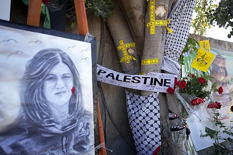 Yellow tape marks bullet holes on a tree and a portrait and flowers create a makeshift memorial at the site where Palestinian-American Al-Jazeera journalist Shireen Abu Akleh was killed. (Photo | AP)