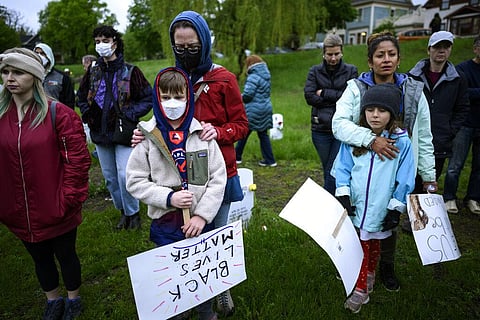 Community members bow their heads in a moment of silence during a vigil at the 'Say Their Names' cemetery Wednesday, May 25, 2022, in Minneapolis. (Photo | AP)
