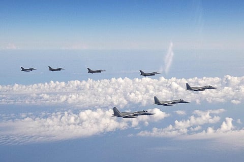 Three F-15 warplanes of the Japanese Self-Defense Force, front, and four F-16 fighters of the U.S. Armed Forces fly over the Sea of Japan. (Photo | AP)