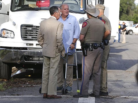 Uvalde Mayor Don McLaughlin, using a walker, speaks with Texas Department of Public Safety troopers outside Robb Elementary School in Uvalde. (Photo | AP)