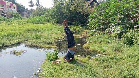 Kathiravan doing a headstand by the banks of Veeracholan river in Mayiladuthurai | Express