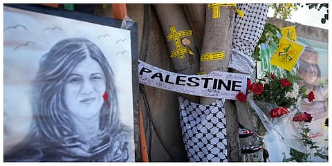 Yellow tape marks bullet holes on a tree and a portrait and flowers create a makeshift memorial at the site where Palestinian-American Al-Jazeera journalist was shot and killed. (Photo | AP)
