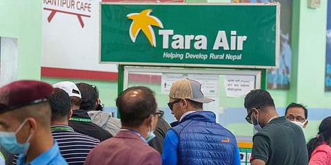 A signage of Tara Airlines is seen behind as a team of climbers prepare to leave for rescue operations. (Photo | AP)