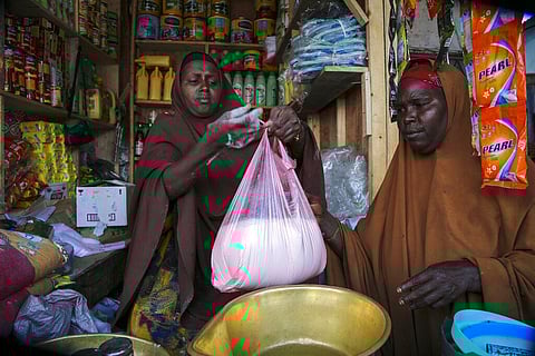 Halimo Hersi, 42, right, buys wheat flour from a shopkeeper in the Hamar-Weyne market in the capital Mogadishu, Somalia Thursday, May 26, 2022. (Photo | AP)
