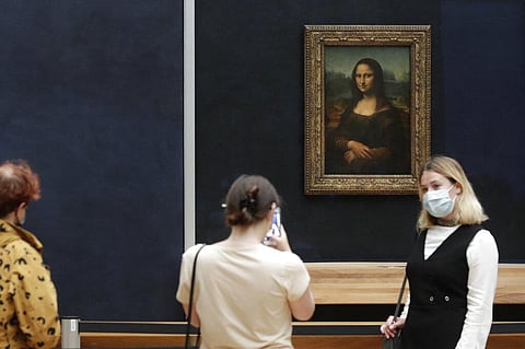 Visitors pose in front of Leonardo da Vinci's Mona Lisa in the Louvre museum, Wednesday, May, 19, 2021 in Paris. (Photo | AP)