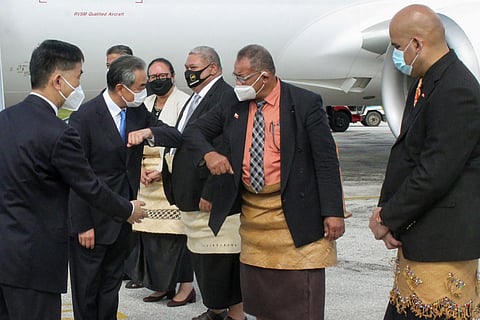 China's Foreign Minister Wang Yi, second left, is welcomed on the tarmac by officials on his arrival in Nuku'alofa, Tonga. (Photo | AP)