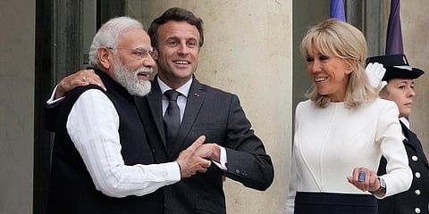 French President Emmanuel Macron (C) and his wife Brigitte Macron (R) welcome PM Narendra Modi prior to a meeting at the Elysee palace in Paris. (Photo | AP)