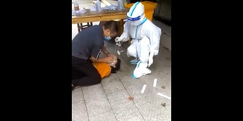 Authorities taking samples for covid test from a citizens forcefully.(Photo | Twitter Screengrab)