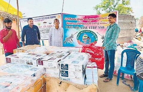 Serving and retired paramilitary force personnel distribute gas stoves and other essentials to tribals in Shanigakunta village of Mulugu district. (Photo | EPS)