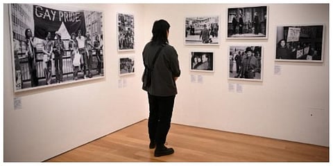 Visitors look at a set of photos displayed in a gallery of the Queer Britain museum, in London. (Photo | AFP)
