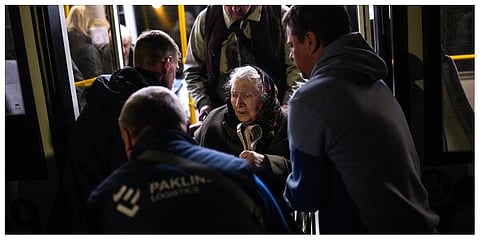 A woman who fled from the Azovstal steel plant in Mariupol is helped from a bus upon her arrival at a reception center for displaced people in Zaporizhzhia, Ukraine. (Photo |AP)
