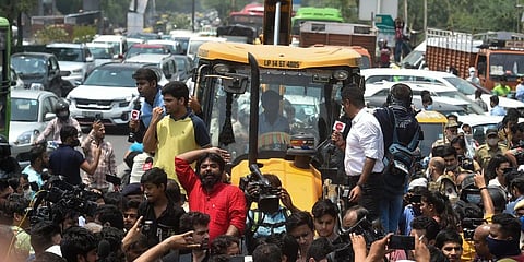 Locals stage a protest in front of a Municipal Corporation of Delhi (MCD) bulldozer at Shaheen Bagh area during an anti-encroachment drive.(Photo | PTI)