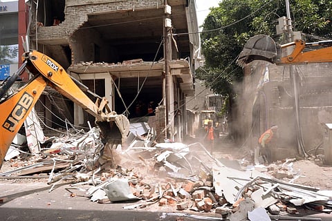 A bulldozer demolishes the construction of the Kanpur violence chief accused Hayat Zafar Hashmi's aide, on Saturday. (Photo | ANI)