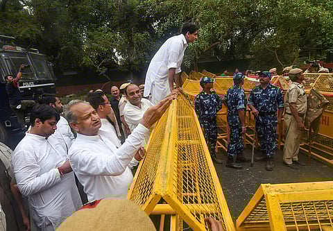 Rajasthan CM Ashok Gehlot with Congress leader Deepender Singh Hooda stand near a police barricade during their protest march from AICC to ED office, in New Delhi, Monday. (Photo | PTI)
