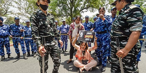 Security personnel stand guard as women Congress workers stage a protest outside the AICC office. (Photo | PTI)