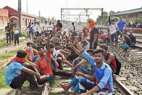 Youngsters sit on railway tracks to protest against the 'Agnipath' scheme, in Buxar. (File photo| PTI)