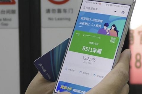 A passenger holds a green pass on a health code app on their phone which indicates their risk level for contracting Covid-19. (File Photo | AP)