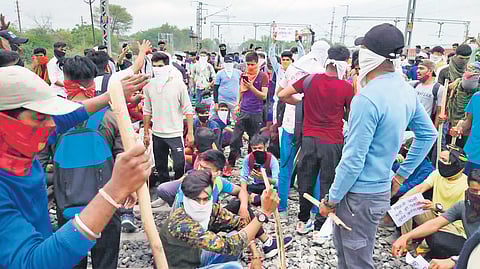 Youth block a railway line while protesting against the ‘Agnipath’ scheme, in Indore on Friday | PTI