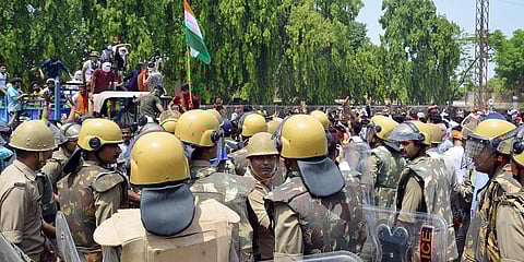 Police personnel stand guard at a demonstration against the Agnipath Recruitment Scheme for the Armed Forces, at the Agra-Delhi national highway, in Mathura. (Photo| PTI)